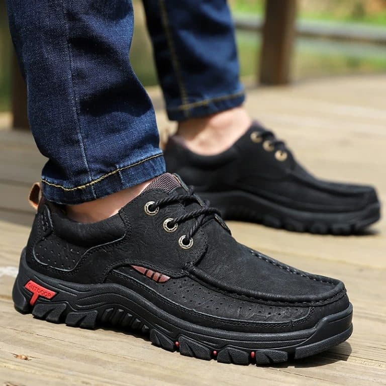 Orthopedic lace-up shoe for men in black leather, side view, worn with jeans.