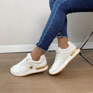 Comfortable women's shoes, white with laces and a small golden heart on the side and a brown sole.