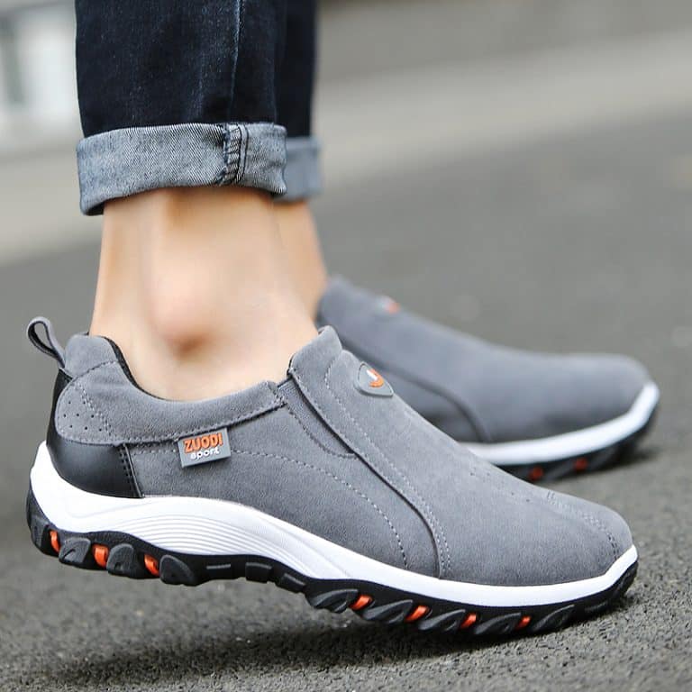 Men's grey suede walking shoes with a white midsole and orange accents.