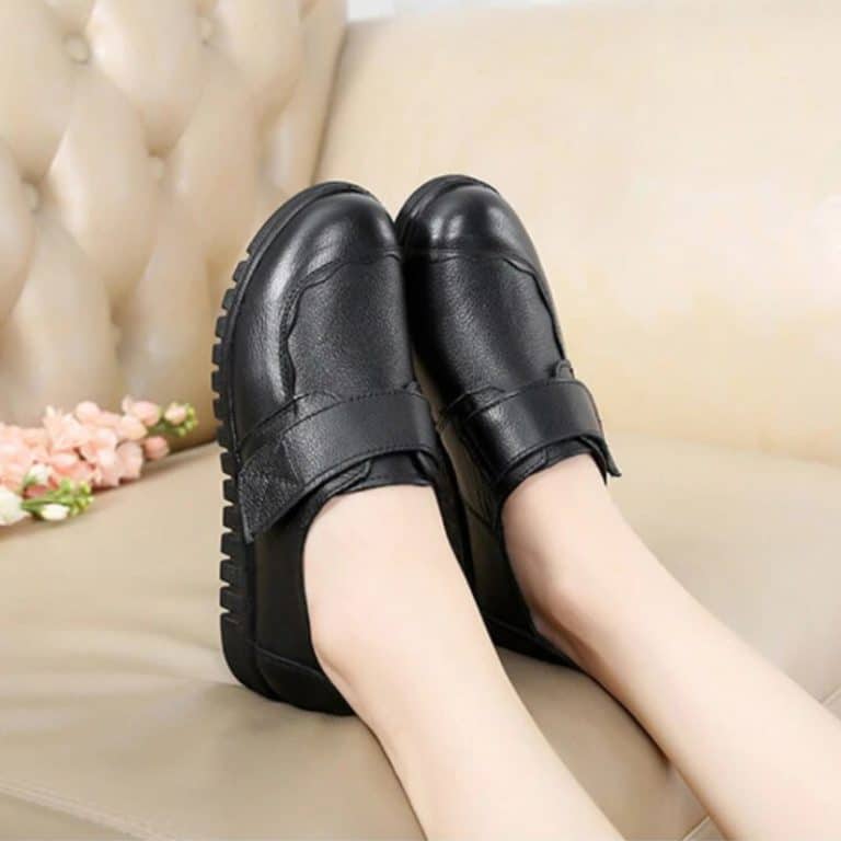 Orthopedic women's shoes in black, worn, viewed from above, with velcro closure.