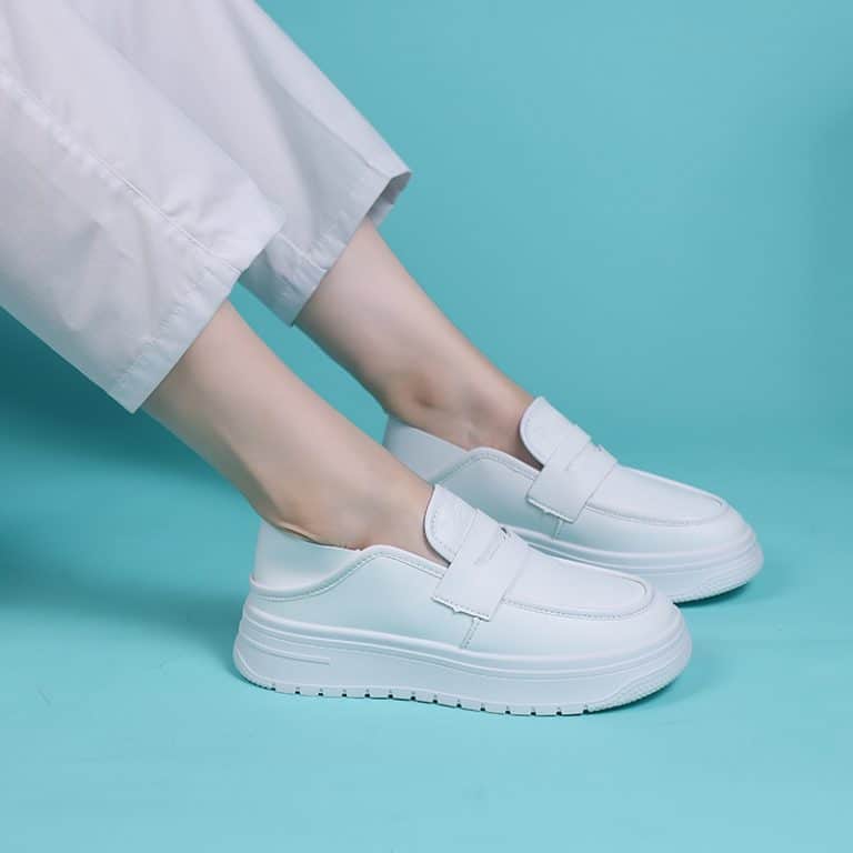 White platform moccasins with velcro closure on turquoise background, for women.
