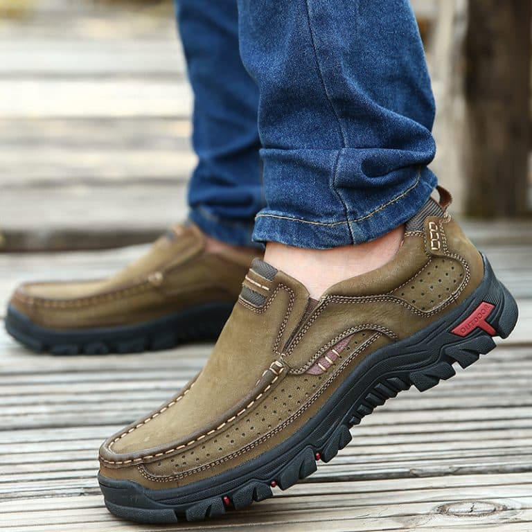 Olive green leather men's loafers with a sturdy black outsole, shown on a lifted foot.