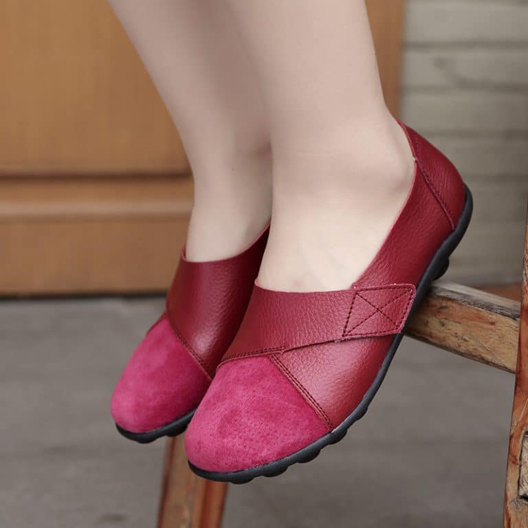 Women's loafers in burgundy red leather with ergonomic black sole and crossed strap.