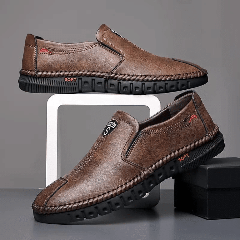 Pair of brown leather shoes for men, featuring a black contoured sole.