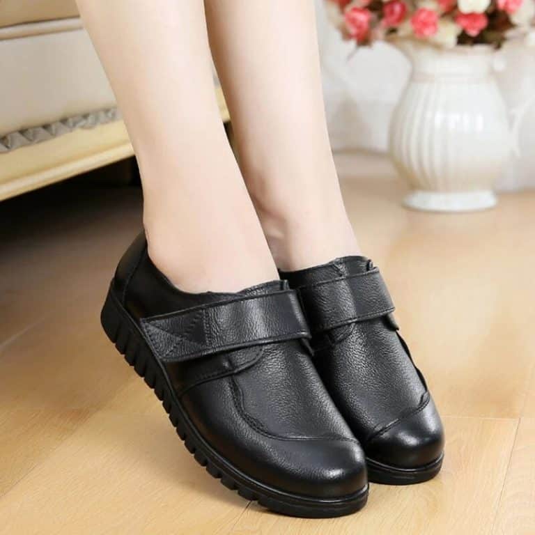 Pair of women's orthopedic shoes, black with velcro closures on the top.