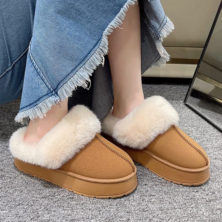 Orthopedic tan slippers for women with a fluffy interior, worn with a denim skirt.