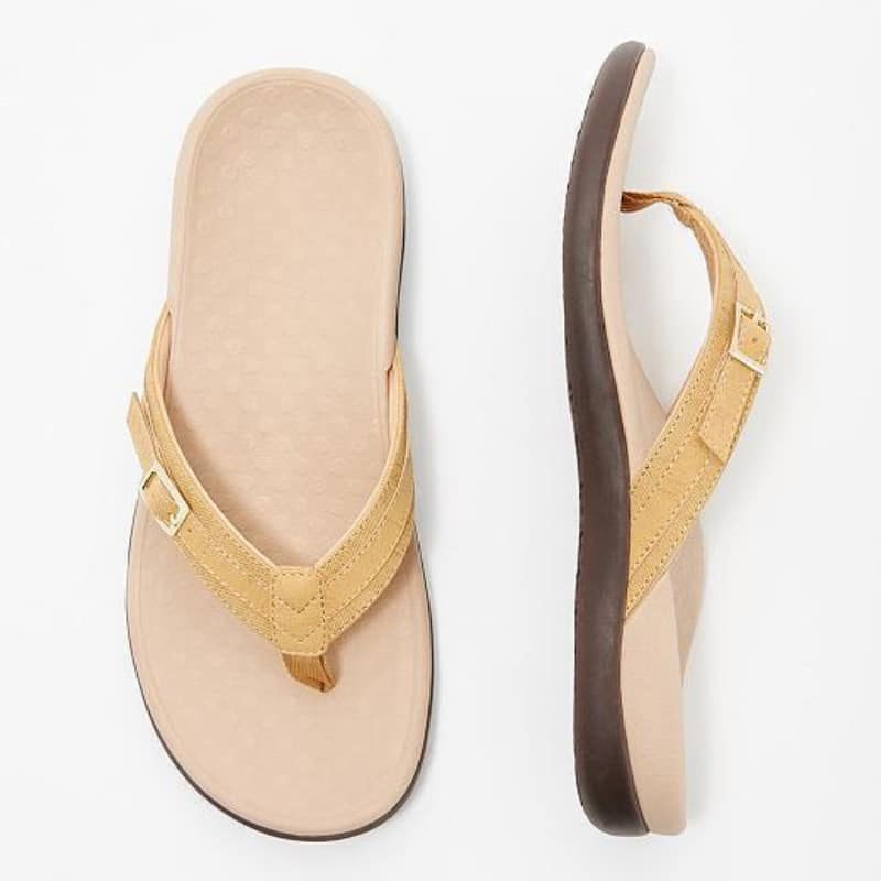 Sandale de plage de style orthopédique pour femme, couleur jaune avec lanière en tissu et boucle dorée, semelle de propreté beige et semelle extérieure marron Orthopedic-style beach sandals for women, yellow with fabric strap and gold buckle, beige insole and brown outsole.