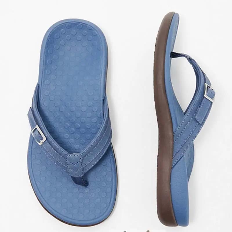 Sandale de plage pour femme en bleu uni avec une lanière et une boucle argentée, semelle intérieure à motifs en relief et semelle extérieure marron Women's solid blue beach sandals with a strap and a silver buckle, inner sole with embossed patterns and brown outer sole.