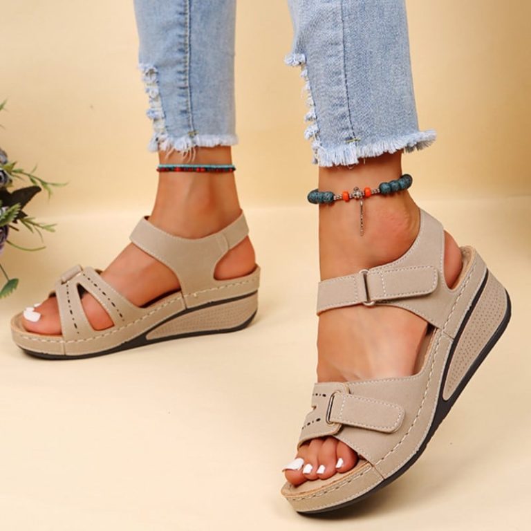 Beige wedge sandals with adjustable straps and side cut-outs.