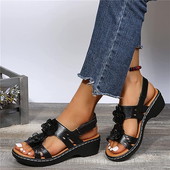 Black wedge heel sandals for women with embossed flowers and back strap.