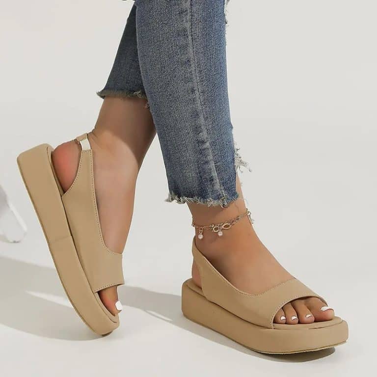 Beige sandals with orthopedic soles for women simple, ripped jeans, and gold ankle bracelet.