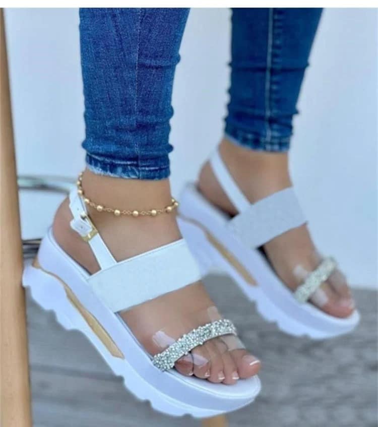Women's white sandals with transparent straps and rhinestones, offering support for high arches, white sole.