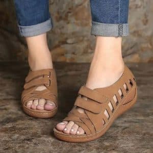 Brown orthopedic women’s sandals with buckle closure and wedge sole.