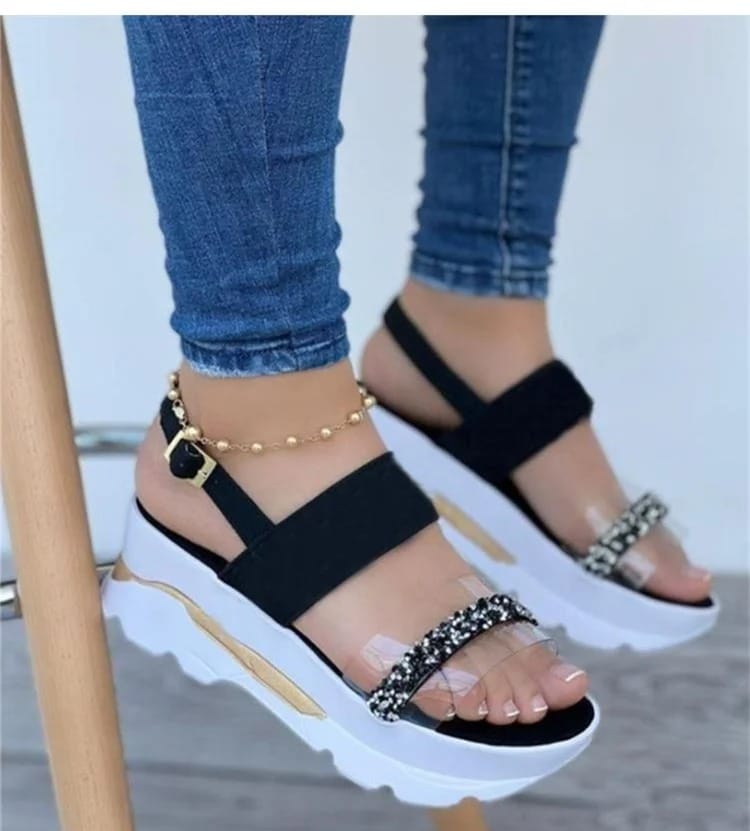 Black sandals with orthopedic support, elastic straps, white sole, and a band of rhinestones.
