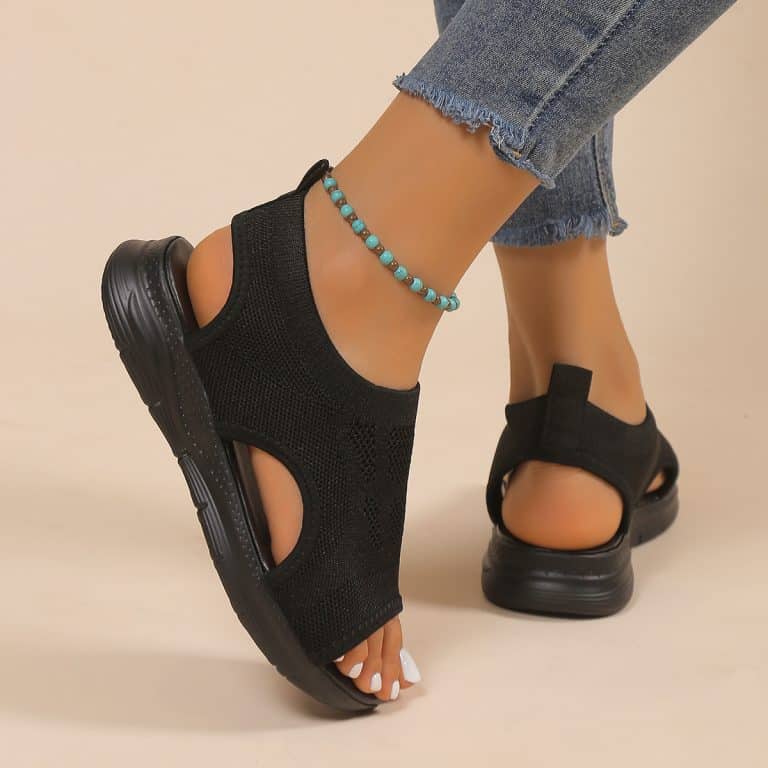 Black mesh sandals with black sole, worn with jeans.