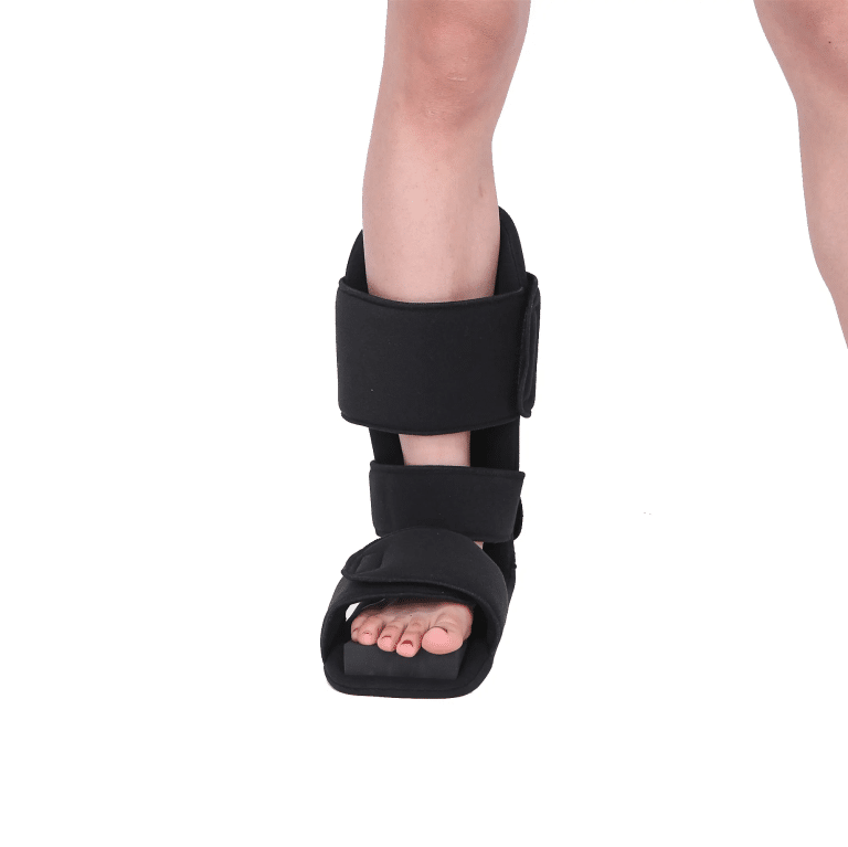 Black orthopedic boot worn on the left foot, with velcro straps.