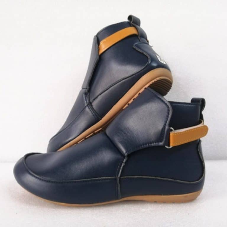 Navy blue leather ankle boots with brown elastic strap and wedge heel.