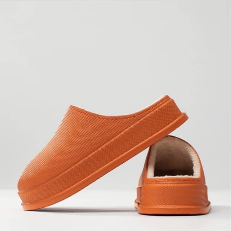 Orange slipper with rigid sole and comfortable plush lining.