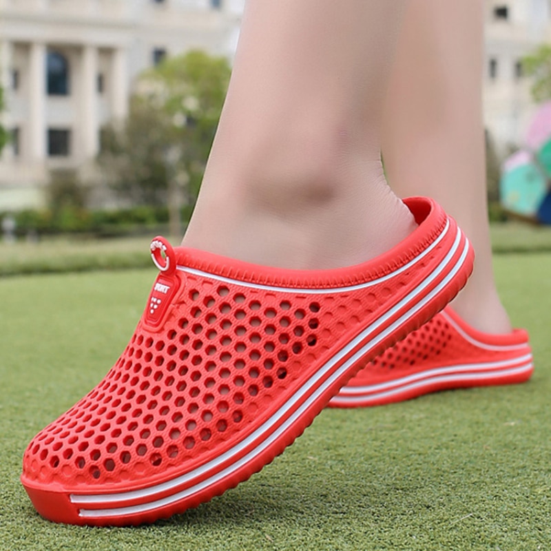 Chaussons d'été orthopédiques pour femme en rouge avec semelle incurvée et perforations pour l'aération Summer orthopedic slippers for women in red with a curved sole and perforations for ventilation.