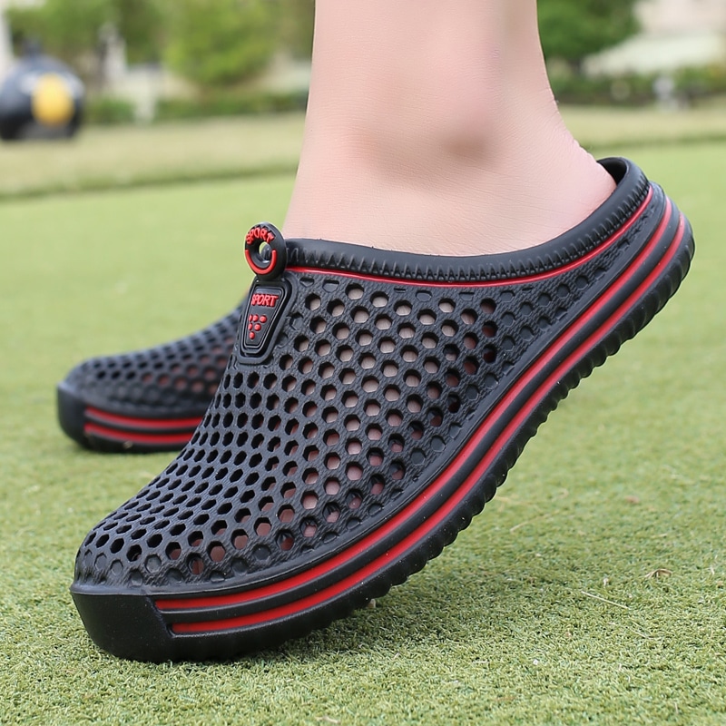 Chaussons noirs avec détails rouge, style sportif, perforés pour l'été, et semelle épaisse Black slippers with red details, sporty style, perforated for the summer, and thick sole.