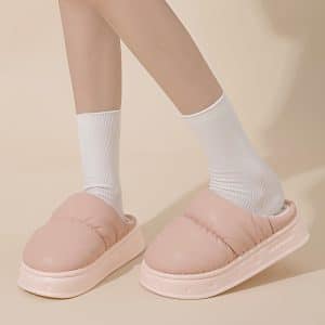 Cream-colored women's slippers with a green interior, thick sole, and quilted design.