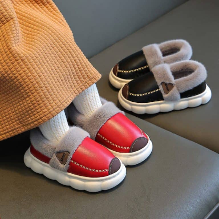 Red and black slippers worn, paired with white socks and an orange sweater.