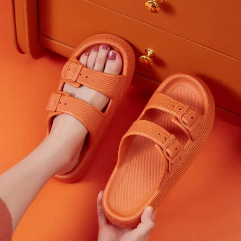 Women's orthopaedic buckle slides in orange, worn, showcasing the adjustable buckles on the top.