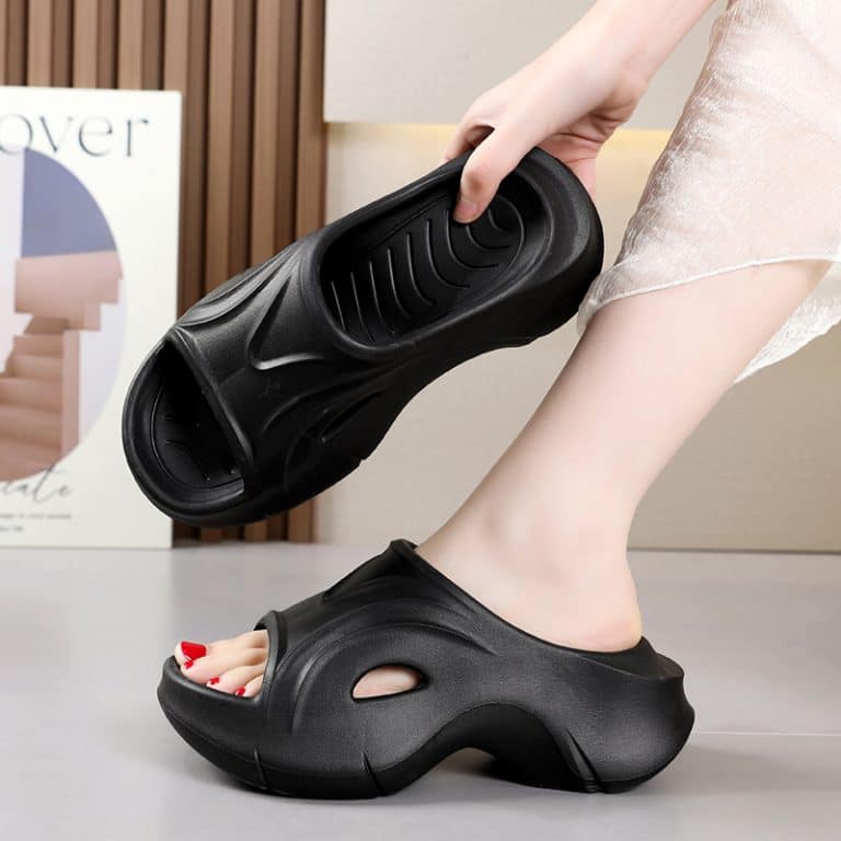 Orthopedic black clogs for women, with a grip demonstrated by a feminine hand.
