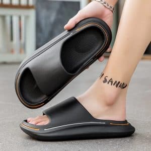 Black orthopedic slides for men with thick sole worn, side view.