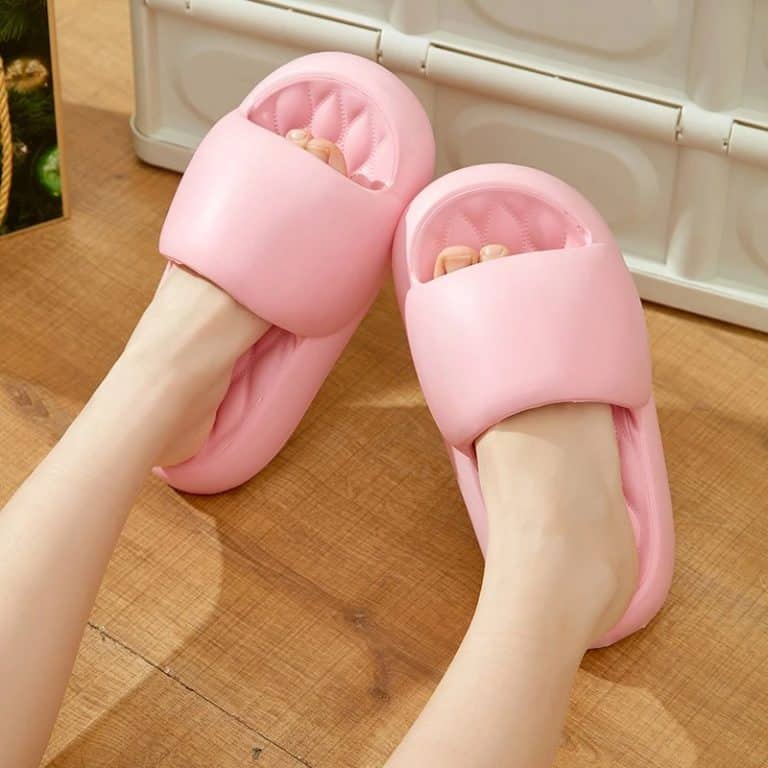 Orthopedic slides for women with thick sole in pale pink color, placed on the ground.