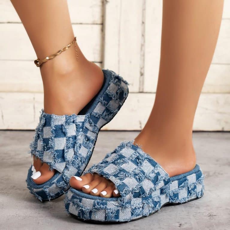 Women's comfort mules in blue checkered denim, frayed design, side view.