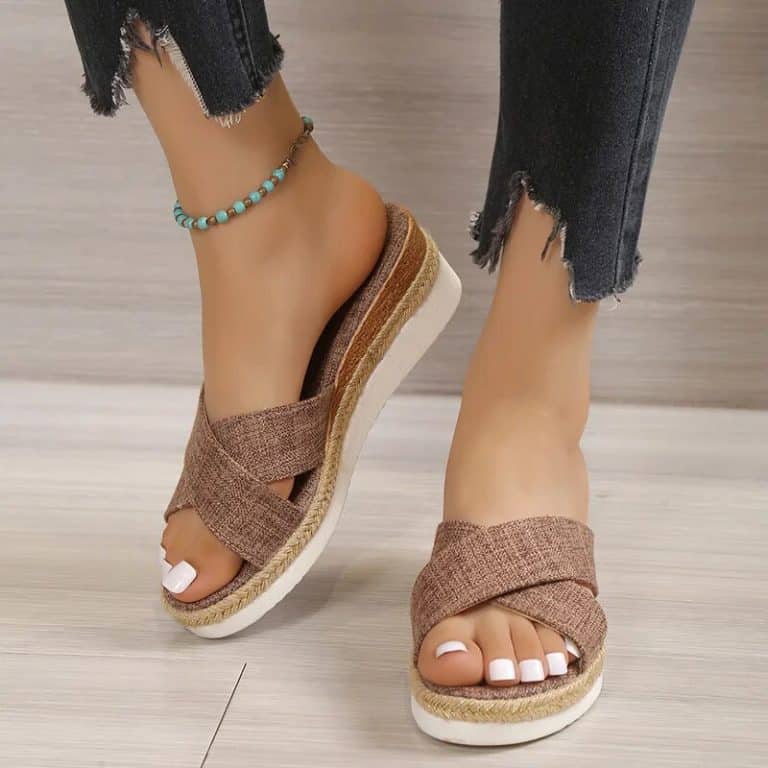 Female brown canvas mules with wedge espadrille sole.