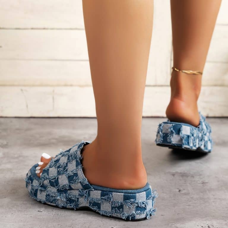 Women's orthopedic denim mules worn, blue checkered pattern, with gold ankle strap.