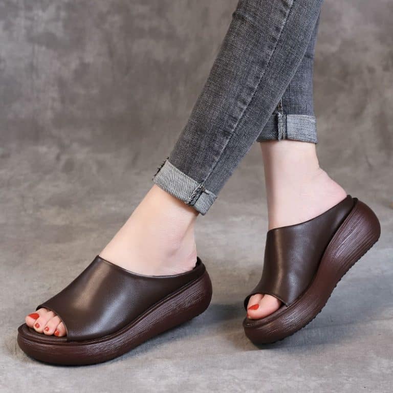 Mules for women with orthopedic support, in black leather, thick sole and visible toe tabs.