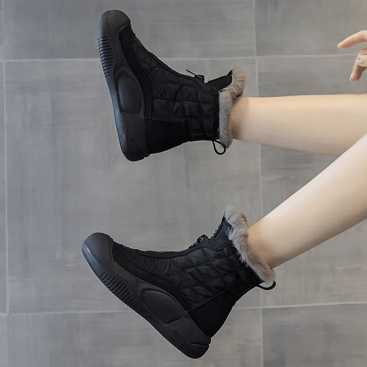 Pair of black ankle boots for women with thick sole and fur lining.