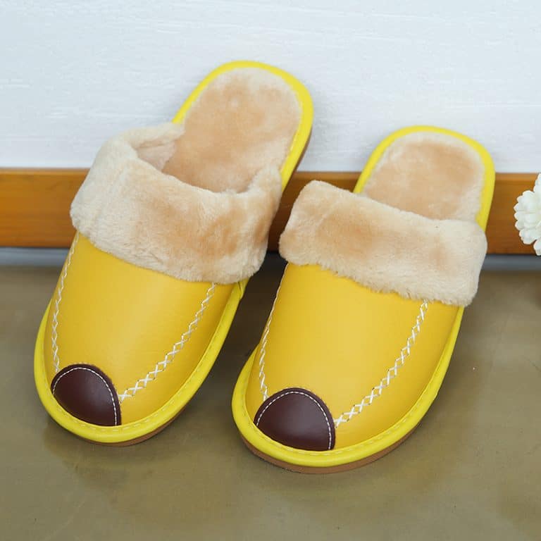 Yellow leather slippers with light fur lining for home comfort.