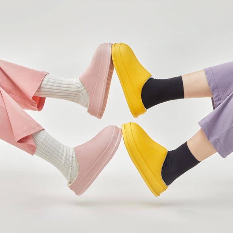 Four feet in the air, two in pink slippers and two in yellow, with thick soles.