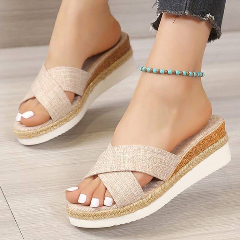 Beige canvas wedge orthopedic sandals, worn with a blue ankle bracelet.