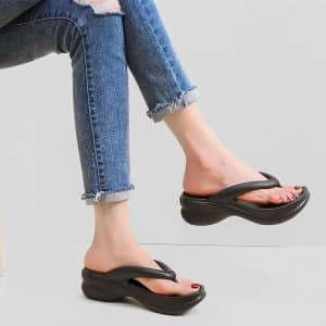 Side view of worn black platform flip-flops, for an elegant look.